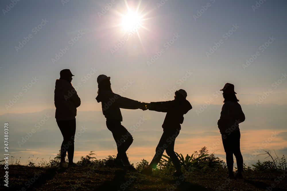 Group of happy people playing at summer sunset in nature Group of happy people playing at summer sunset in nature