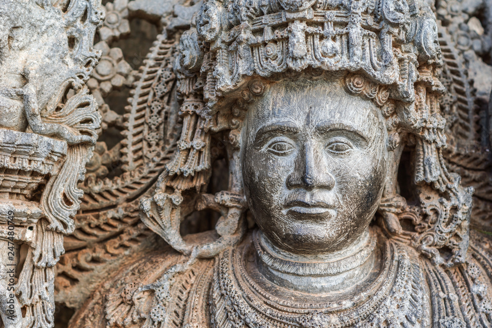 Halebidu, Karnataka, India - November 2, 2013: Hoysaleswara Temple of Shiva. Closeup of Dwarapalaka face at entrance to Mandapam of main temple building. Gray brown stone. 
