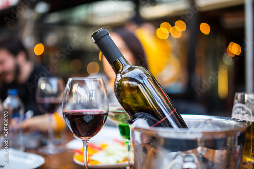 red wine in a glass and bottle with ice bucket
