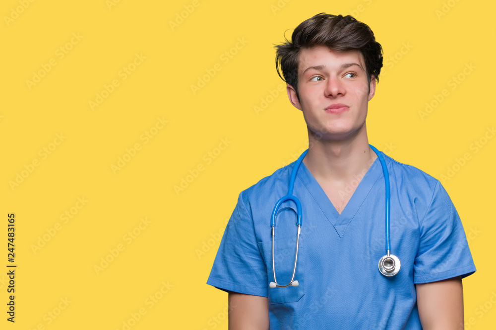 Young doctor wearing medical uniform over isolated background smiling looking side and staring away thinking. Young doctor wearing medical uniform over isolated background smiling looking side and staring away thinking.