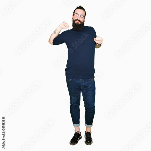 Young hipster man with long hair and beard wearing glasses stretching back, tired and relaxed, sleepy and yawning for early morning