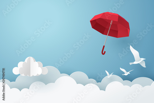 Paper art of red umbrella fly above the cloud on the sky