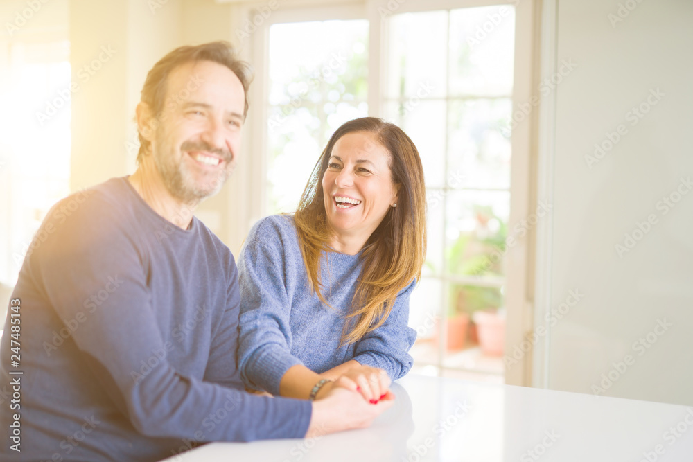 Romantic middle age couple sitting together at home Romantic middle age couple sitting together at home
