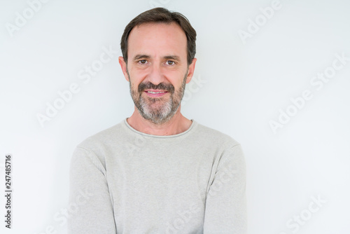 Elegant senior man over isolated background with serious expression on face. Simple and natural looking at the camera. © Krakenimages.com