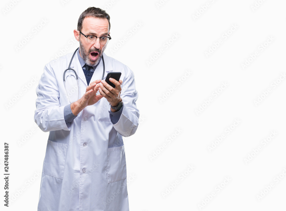 Middle age senior hoary doctor man texting using smartphone over isolated background scared in shock with a surprise face, afraid and excited with fear expression Middle age senior hoary doctor man texting using smartphone over isolated background scared in shock with a surprise face, afraid and excited with fear expression