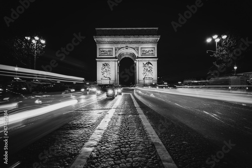 Traffic on Avenue des Champs-Élysées and the Arc de Triomphe at night in Paris, France.