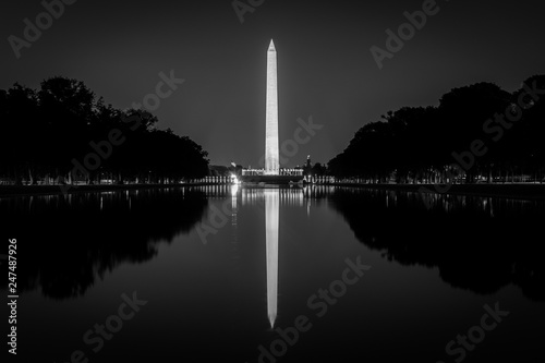 The Washington Monument reflecting in the Reflection Pool at night at the National Mall in Washington, DC.