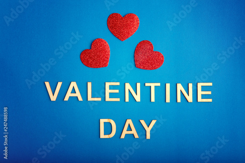 Happy Valentine Day. Beautiful card wallpaper with three red hearts in centre on blue background. Gradient toned backdrop. Concept of polygamy love and February holiday.