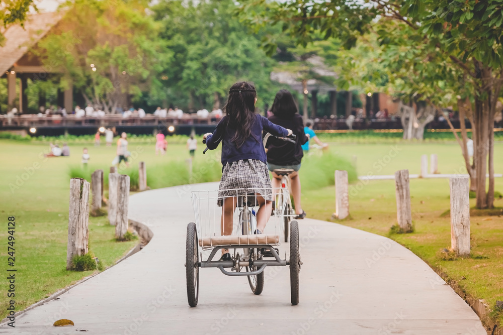 People exercising by cycling in the evening at the public park. People exercising by cycling in the evening at the public park.