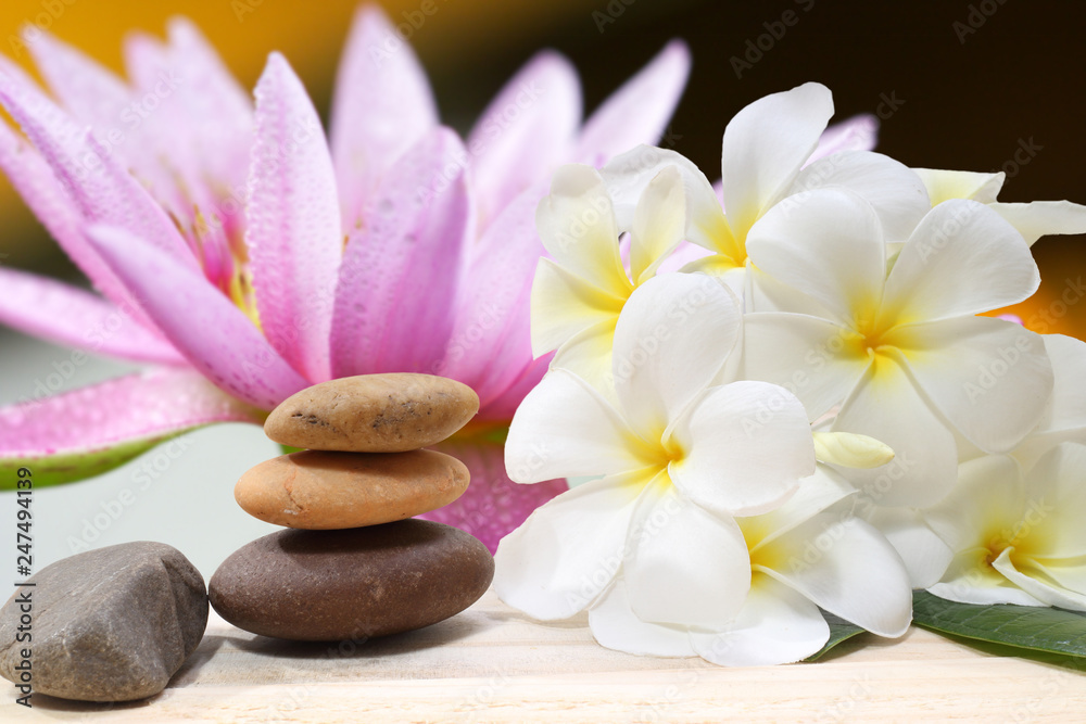 Zen spa concept background - Zen massage stones with frangipani plumeria flower Zen spa concept background - Zen massage stones with frangipani plumeria flower