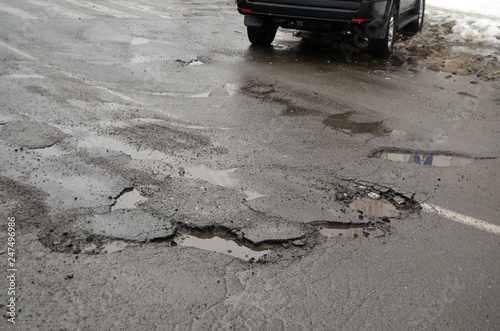 Poor condition of the road surface. Winter season. Wet and foggy weather. Residential area of Kiev.  photo