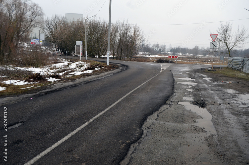 Poor condition of the road surface. Winter season. Wet and foggy weather. Residential area of Kiev. 