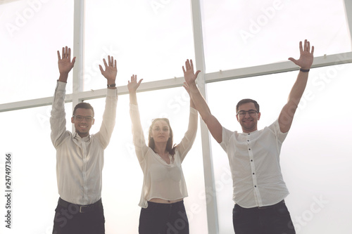 successful business team stands with hands up.