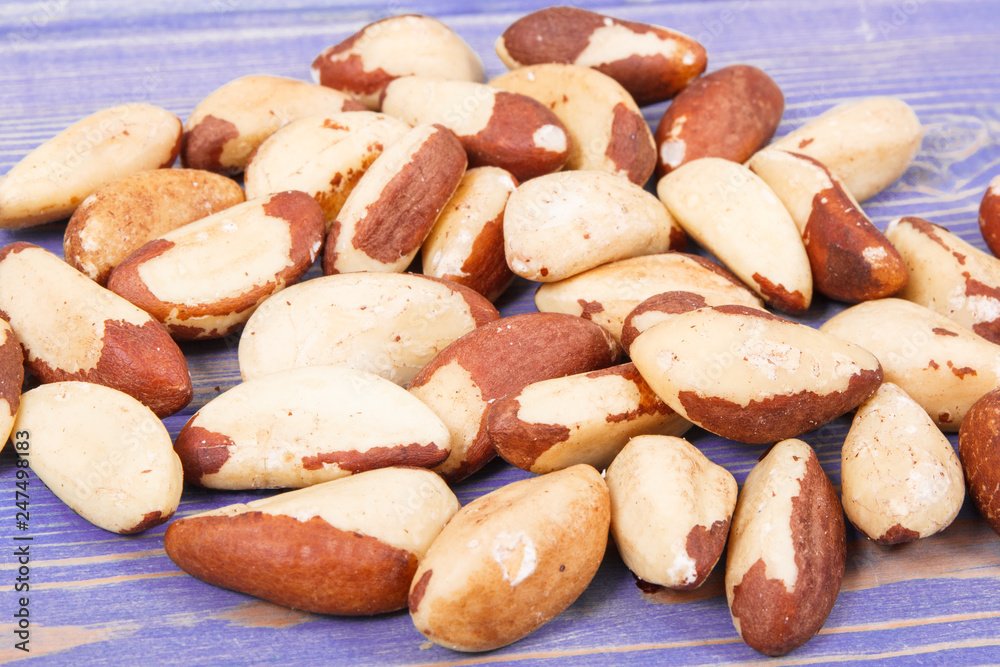 Obraz premium Heap of brazil nuts on old purple boards