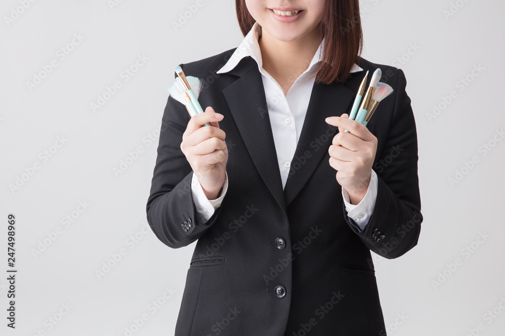 スーツ姿でメイク道具を持つ女の子 スーツ姿でメイク道具を持つ女の子