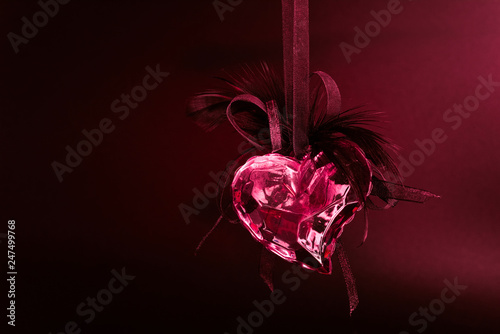 Symbol of love and passion. Glass, fiery, red heart, heart on a dark background. photo