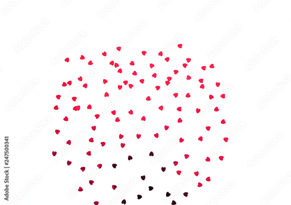 Festive white background with red spangles in the shape of heart. 