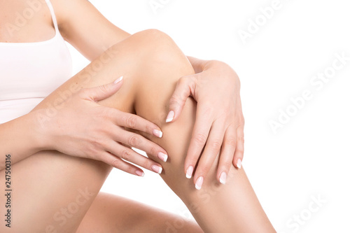 Applying moisturizer cream. Care for female legs isolated on white background. Skin care concept.