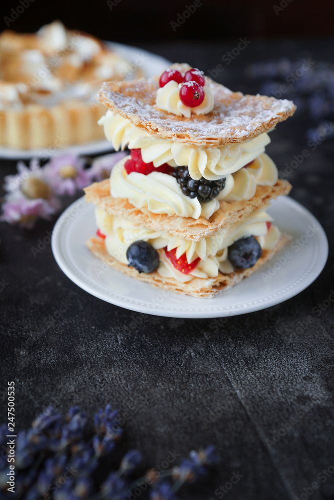 Tea and sweets on a dark background, Mille-feuille, Eclairs, Tart, Decorative with flowers, Selective focus, Closeup Tea and sweets on a dark background, Mille-feuille, Eclairs, Tart, Decorative with flowers, Selective focus, Closeup