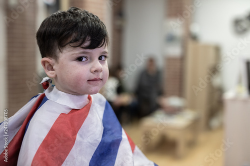 Young boy cuts his hair in the modern hairdresser
