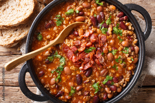 American cowboy beans with ground beef, bacon in a spicy sauce close-up. horizontal top view