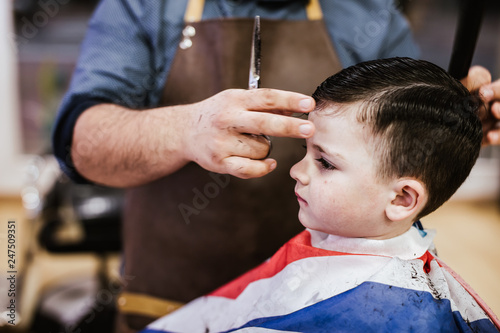 Young boy cuts his hair in the modern hairdresser