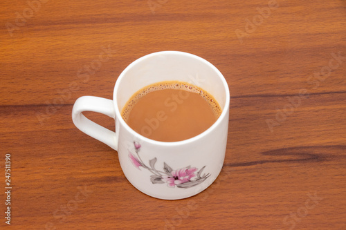 Cup of tea with milk isolated on wooden background
