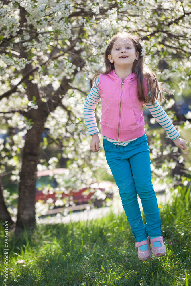 Cute girl in a blooming cherry tree garden Cute girl in a blooming cherry tree garden
