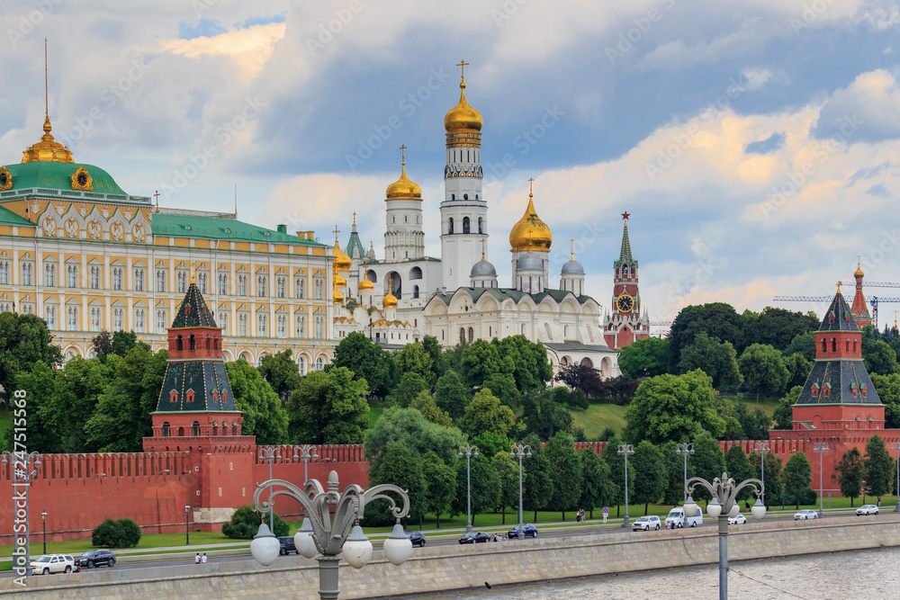 Obraz premium Grand Kremlin Palace and Cathedral of the Annunciation on a background of embankment of Moskva river against cloudy sky