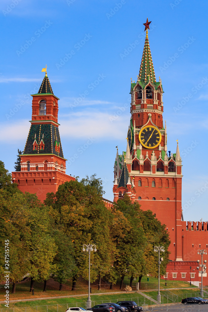 Moscow Kremlin towers on a background of blue sky and green trees in sunny early morning
