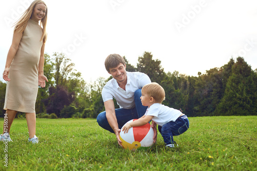 Family with a child playing with a ball in the park.