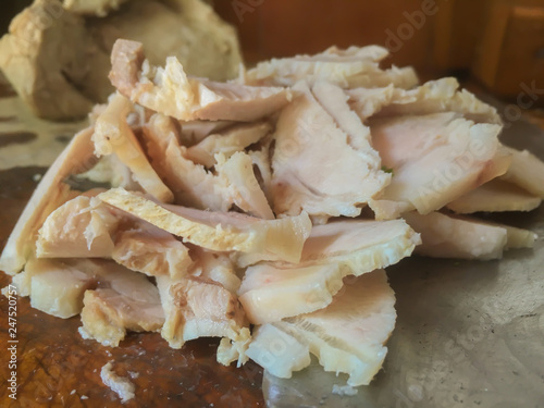 closeup of traditional cooked pork slide on wood with knife