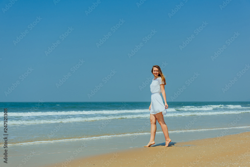Beautiful Girl in White Dress Enjoy and Relax on The Beach. Travel and Vacation. Beautiful Girl in White Dress Enjoy and Relax on The Beach. Travel and Vacation.