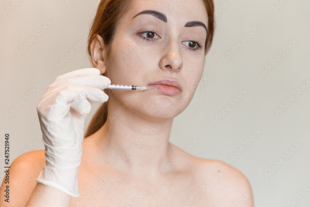 Natural look of young woman gets cosmetic injection. Doctors hands making an injection in face. Beauty Treatment Natural look of young woman gets cosmetic injection. Doctors hands making an injection in face. Beauty Treatment