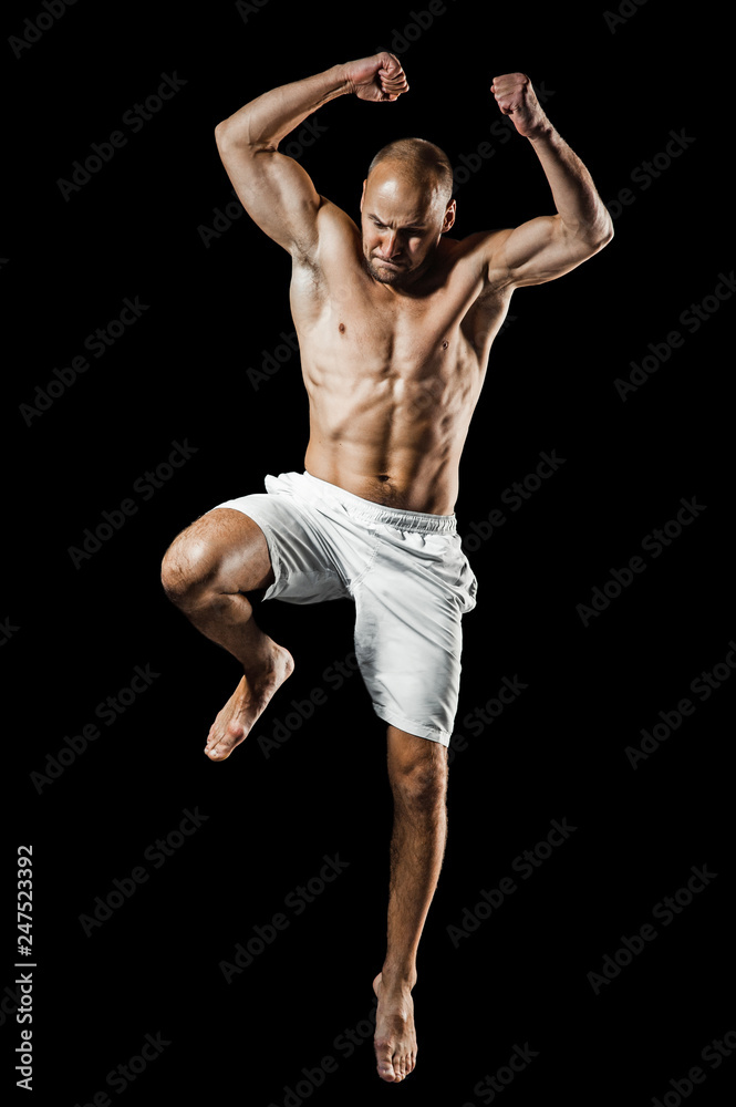 Male athlete muay thai boxer fighting. Isolated on black background. Copy Space. Fight, box, MMA, sport concept. Male athlete muay thai boxer fighting. Isolated on black background. Copy Space. Fight, box, MMA, sport concept.