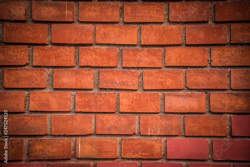Detail of red brick wall background with dark vignette in corners