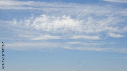 Timelapse Cloud Formation Moving Diagonally Left And Backwards On Beautiful Blue Sky photo