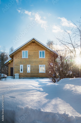 Wooden house in the russian countryside in winter. There is two-story house of timber. Frosty sunny day. © svetlana_cherruty