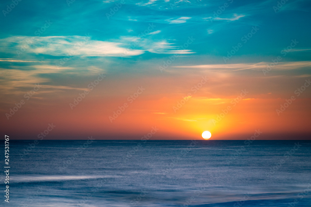 Obraz premium golden and red skies over the mediterranean sea from Valencia in spain in europe on a cold crisp winter day