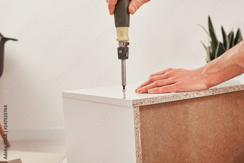 The furniture assembler joins together the two parts of the ready-to ...