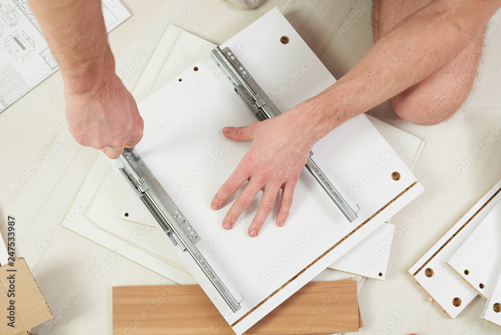 The furniture assembler joins together the two parts of the readyto