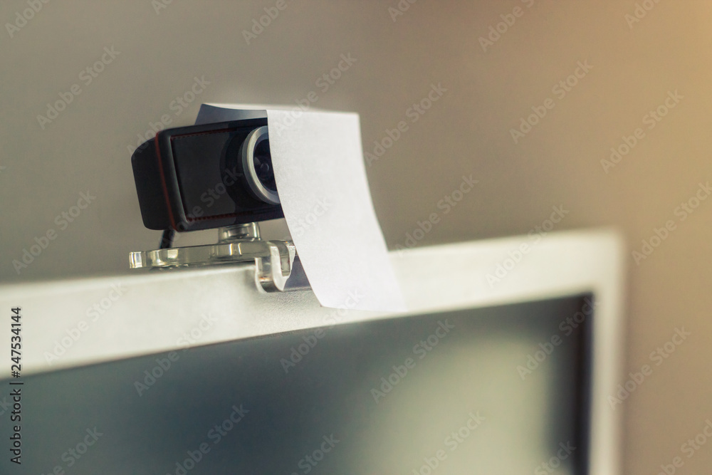 Naklejka premium web camera covered with a sheet of paper, the concept of protection from peony, surveillance. Observation of people, concept.defense from hackers