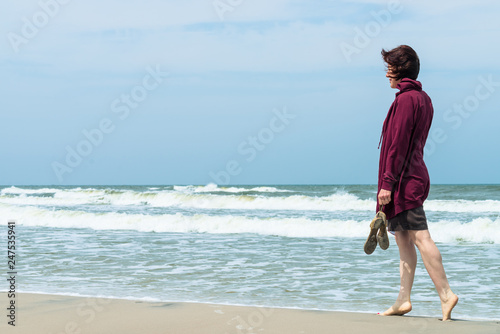 Woman walking on beach © Voyagerix