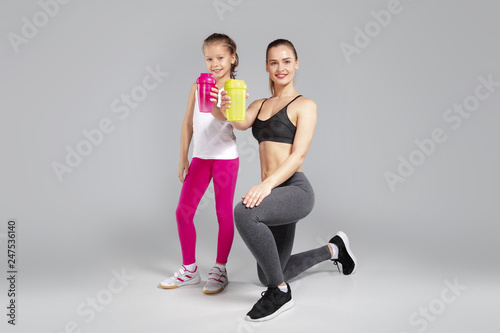 Beautiful woman and her daughter with thermal mugs