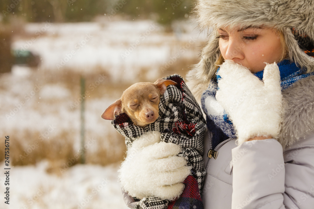 Woman hug warming her little dog in winter Woman hug warming her little dog in winter
