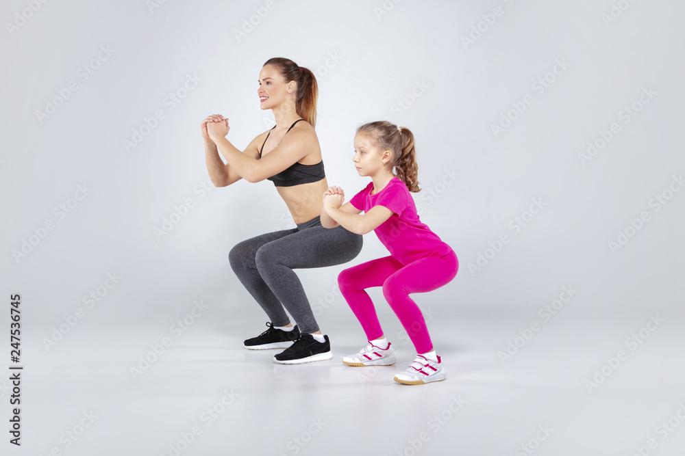 Female trainer and 10 years old girl are doing gym exercises Female trainer and 10 years old girl are doing gym exercises
