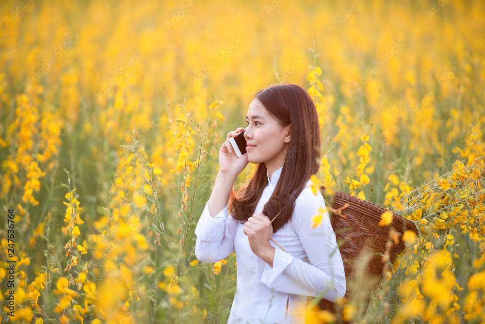 Asian woman wearing traditional dress texting on a smartphone Asian woman wearing traditional dress texting on a smartphone