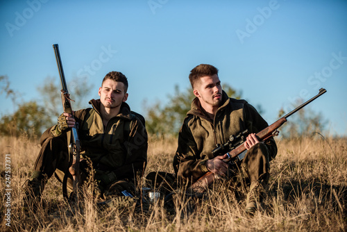 Hunters with rifles relaxing in nature environment. Hunting with friends hobby leisure. Hunters friends enjoy leisure. Hunters satisfied with catch drink warming beverage. Rest for real men concept