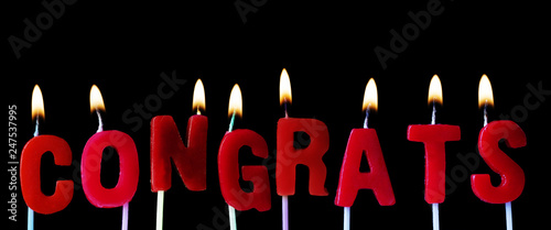 Congrats spellt out in red birthday candles against a black background