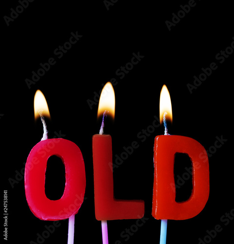 Old spellt out in red birthday candles against a black background